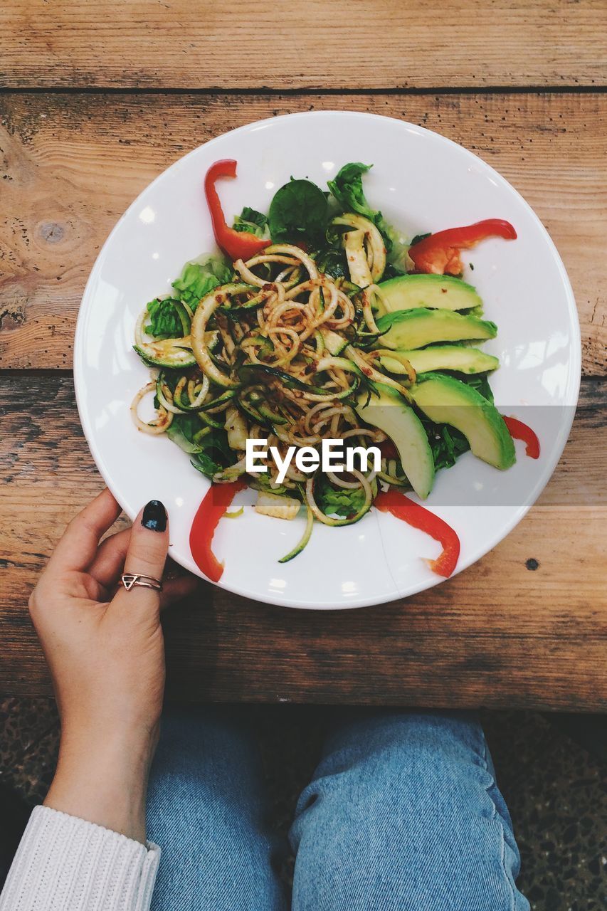 High angle view of woman eating noodles at table