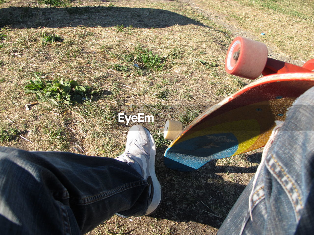 LOW SECTION OF PERSON WEARING SHOES ON GRASS