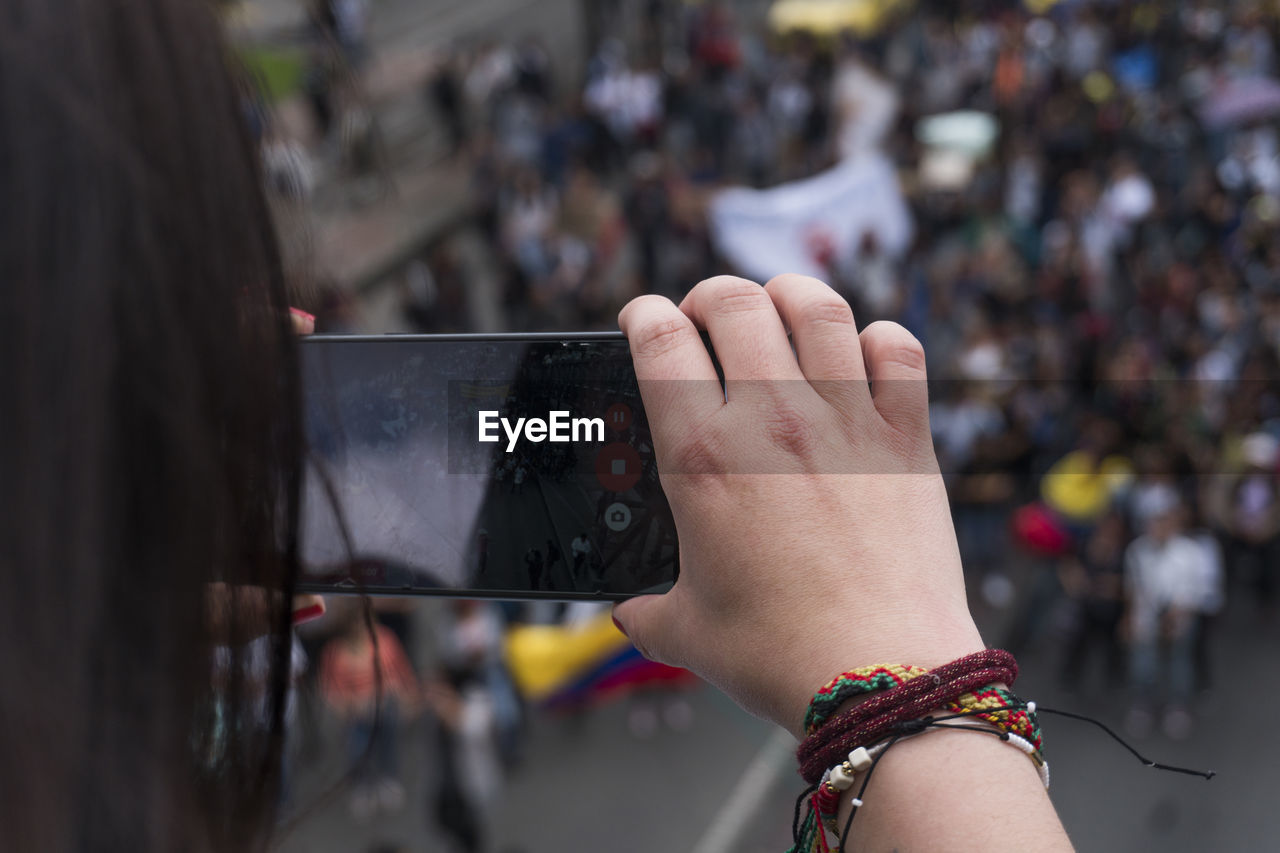 Close-up of woman photographing with mobile phone in city