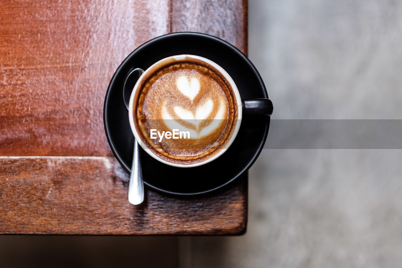 COFFEE CUP ON TABLE AGAINST WALL