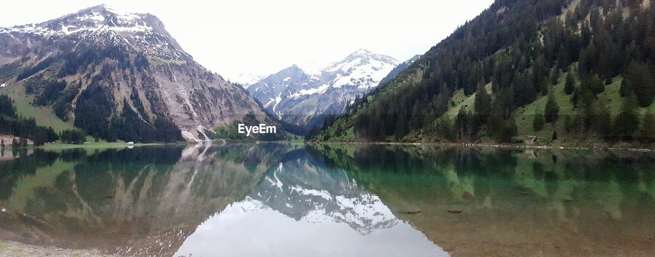 REFLECTION OF MOUNTAINS IN LAKE DURING WINTER