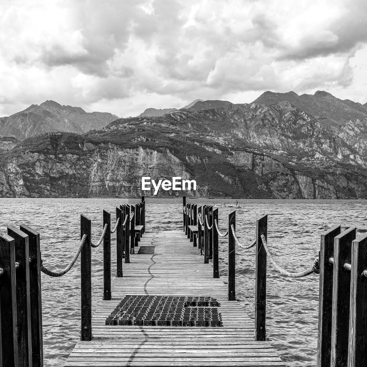 Wooden posts on pier by sea against sky