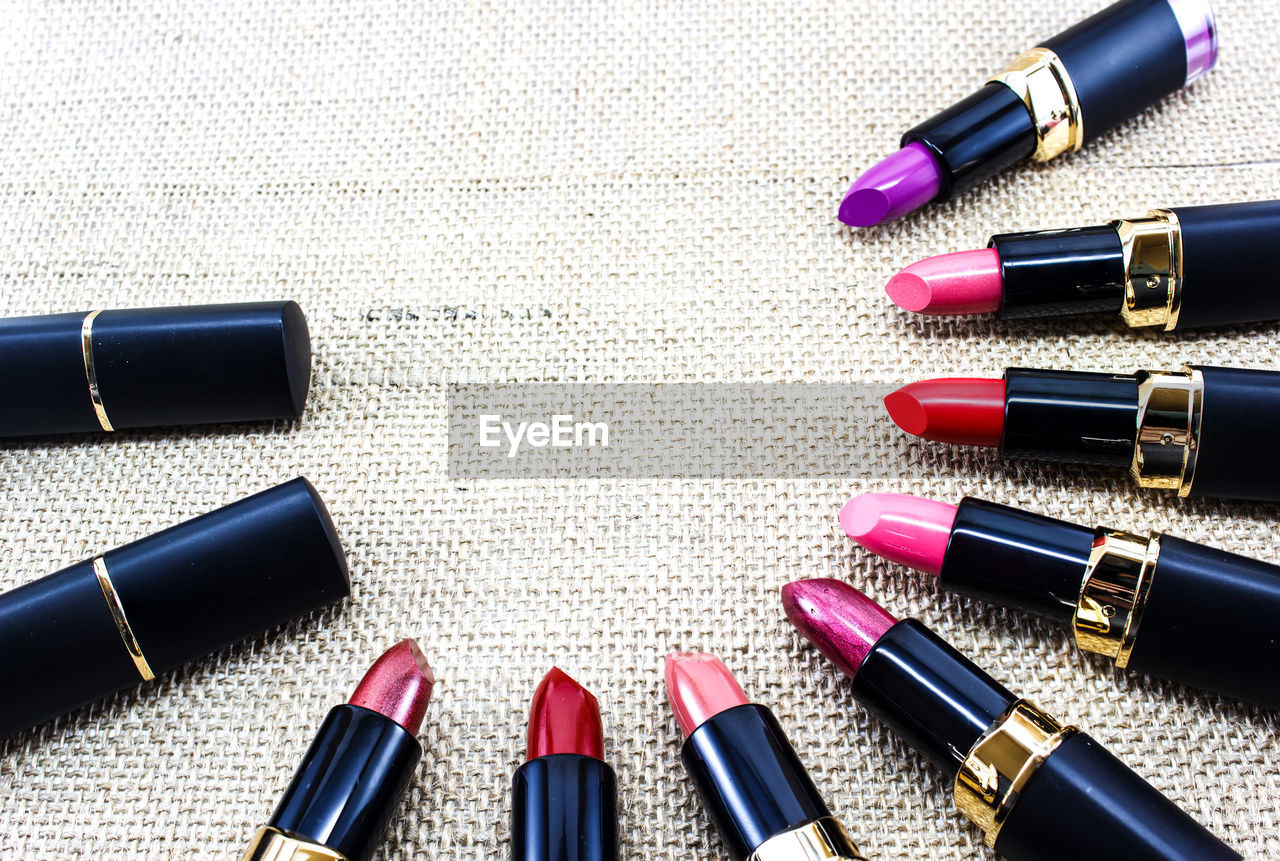 High angle view of colorful lipsticks arranged on burlap