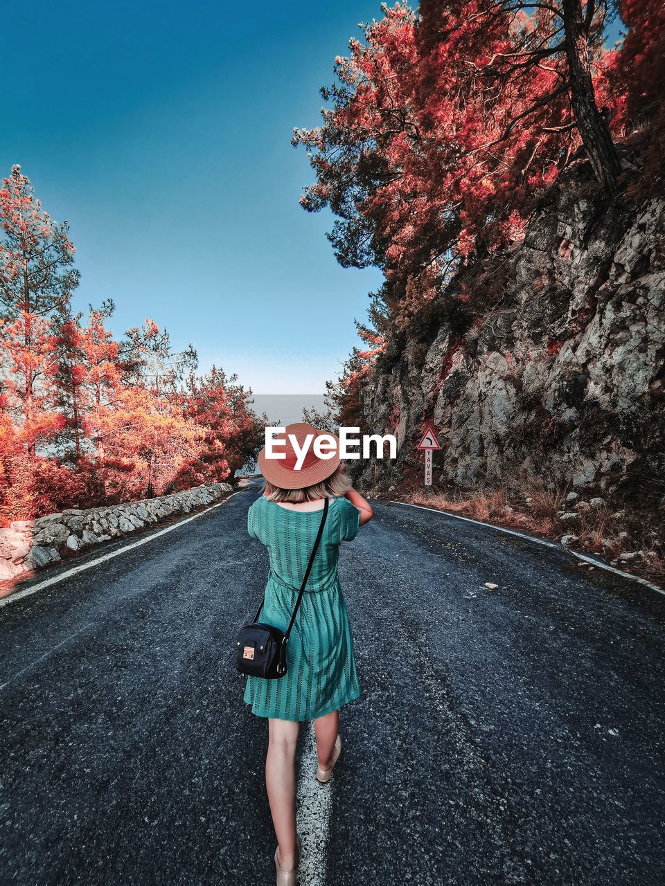 Rear view of woman walking on road