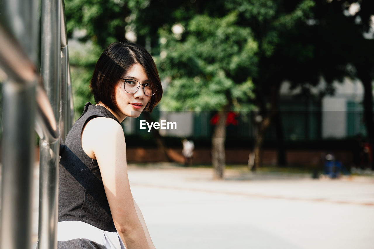 Portrait of woman in eyeglasses standing outdoors
