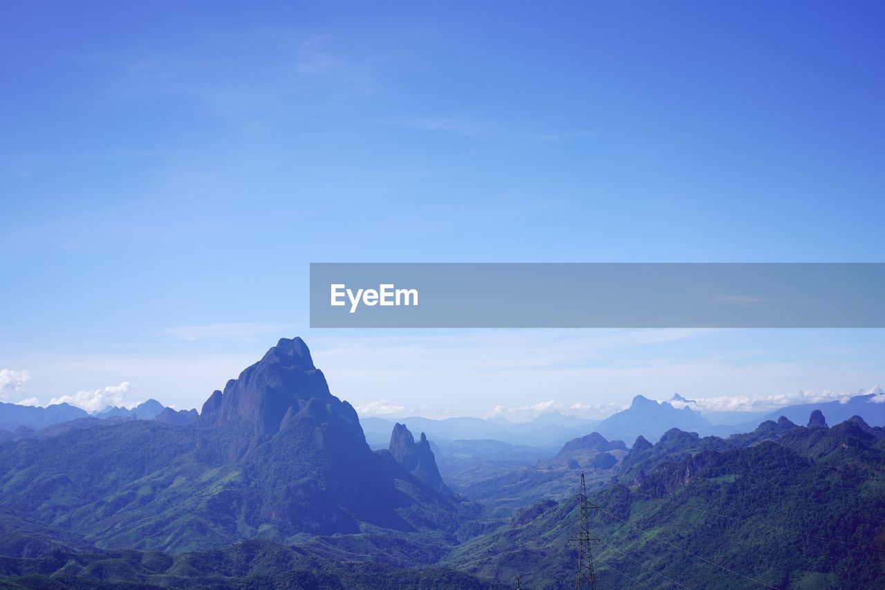 Scenic view of mountains against blue sky