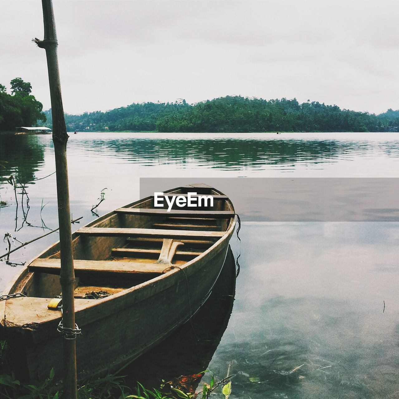 Wooden boat in lake with trees in background