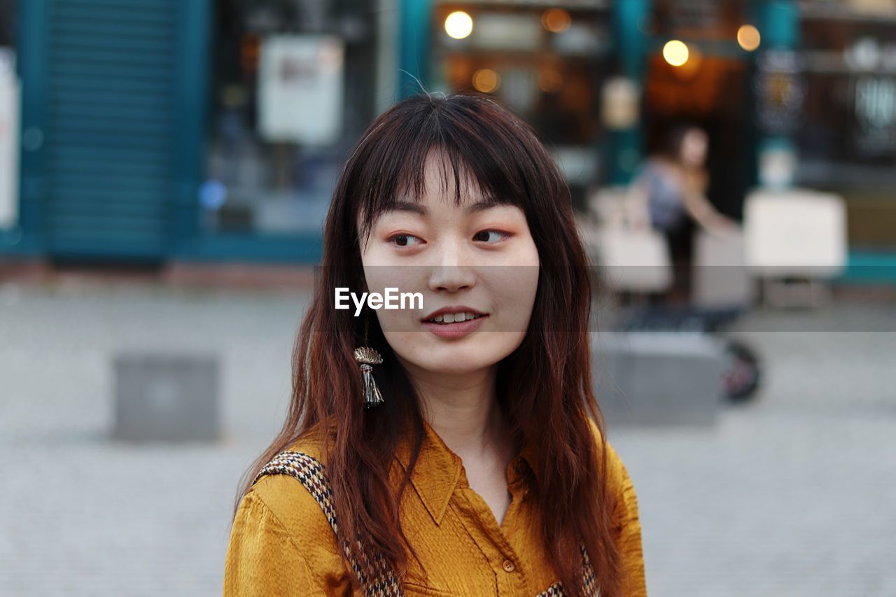 Close-up of woman looking away in city