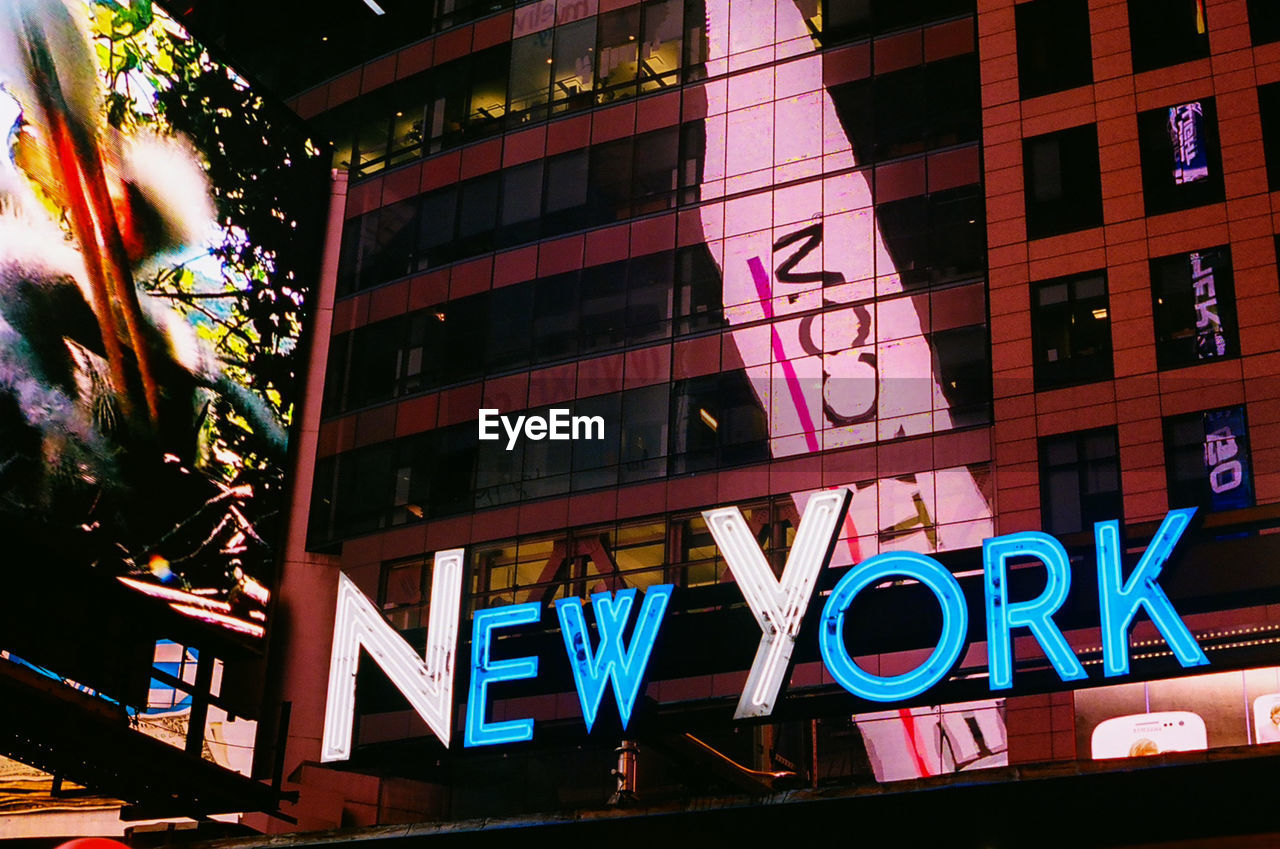 LOW ANGLE VIEW OF TEXT ON BUILDING AT NIGHT