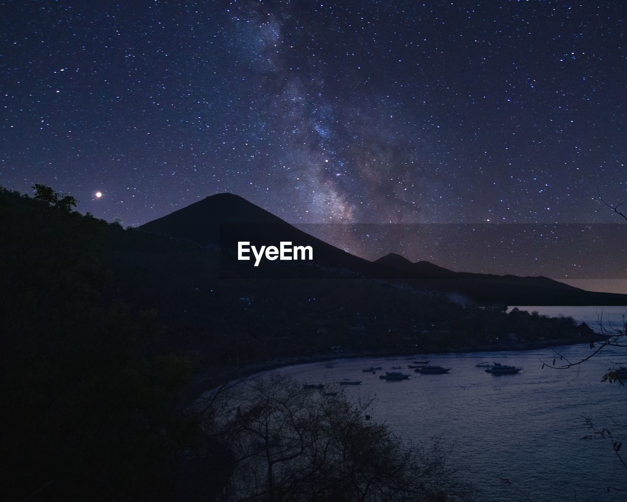 Scenic view of lake against sky at night