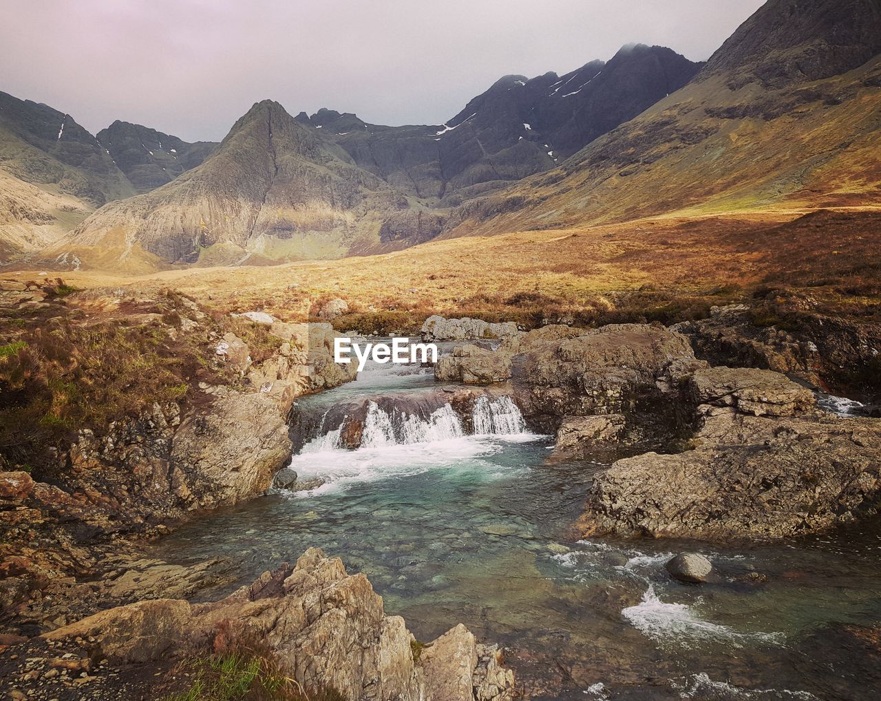 SCENIC VIEW OF STREAM IN MOUNTAINS