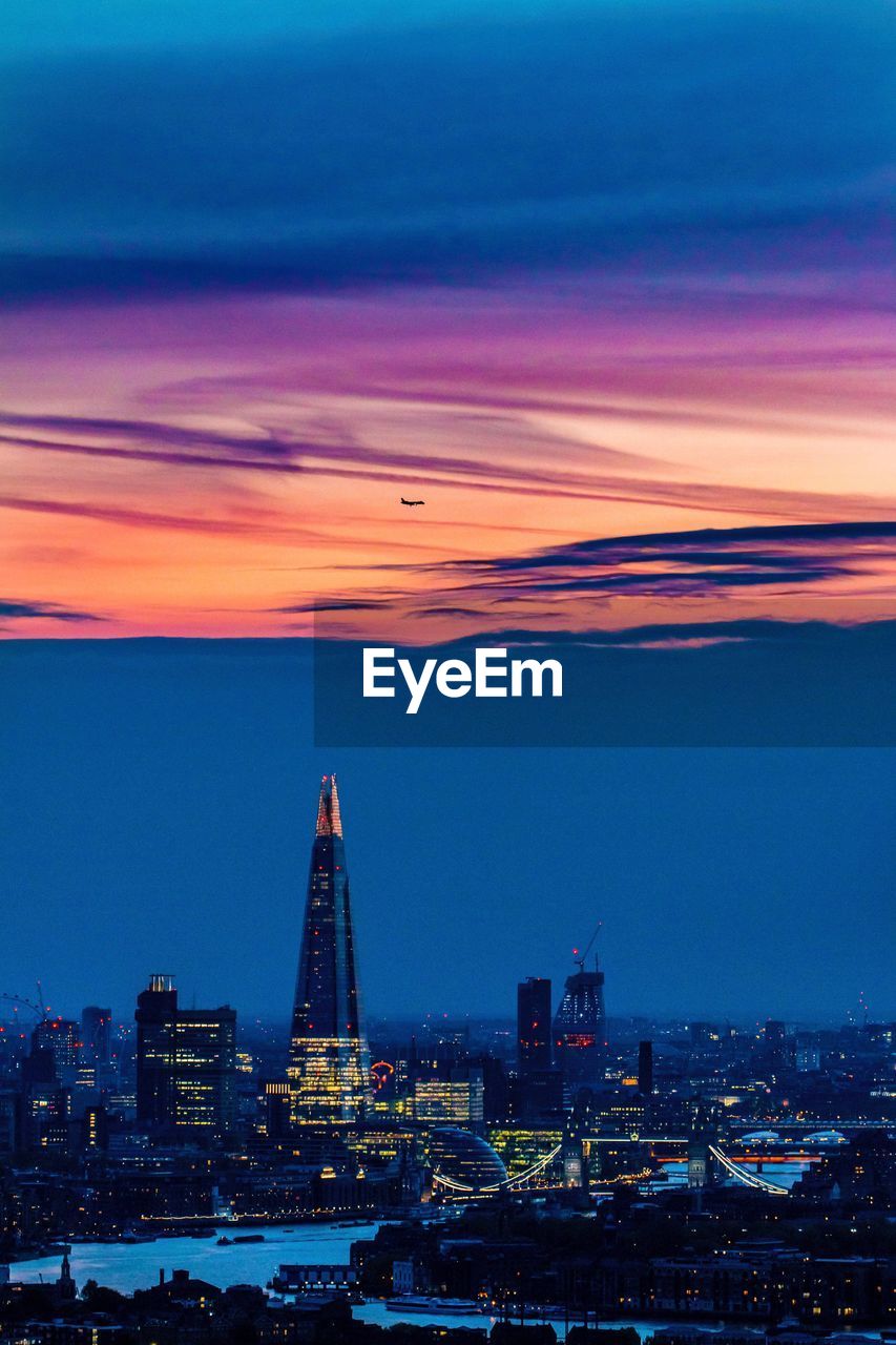 Aerial view of city lit up at sunset