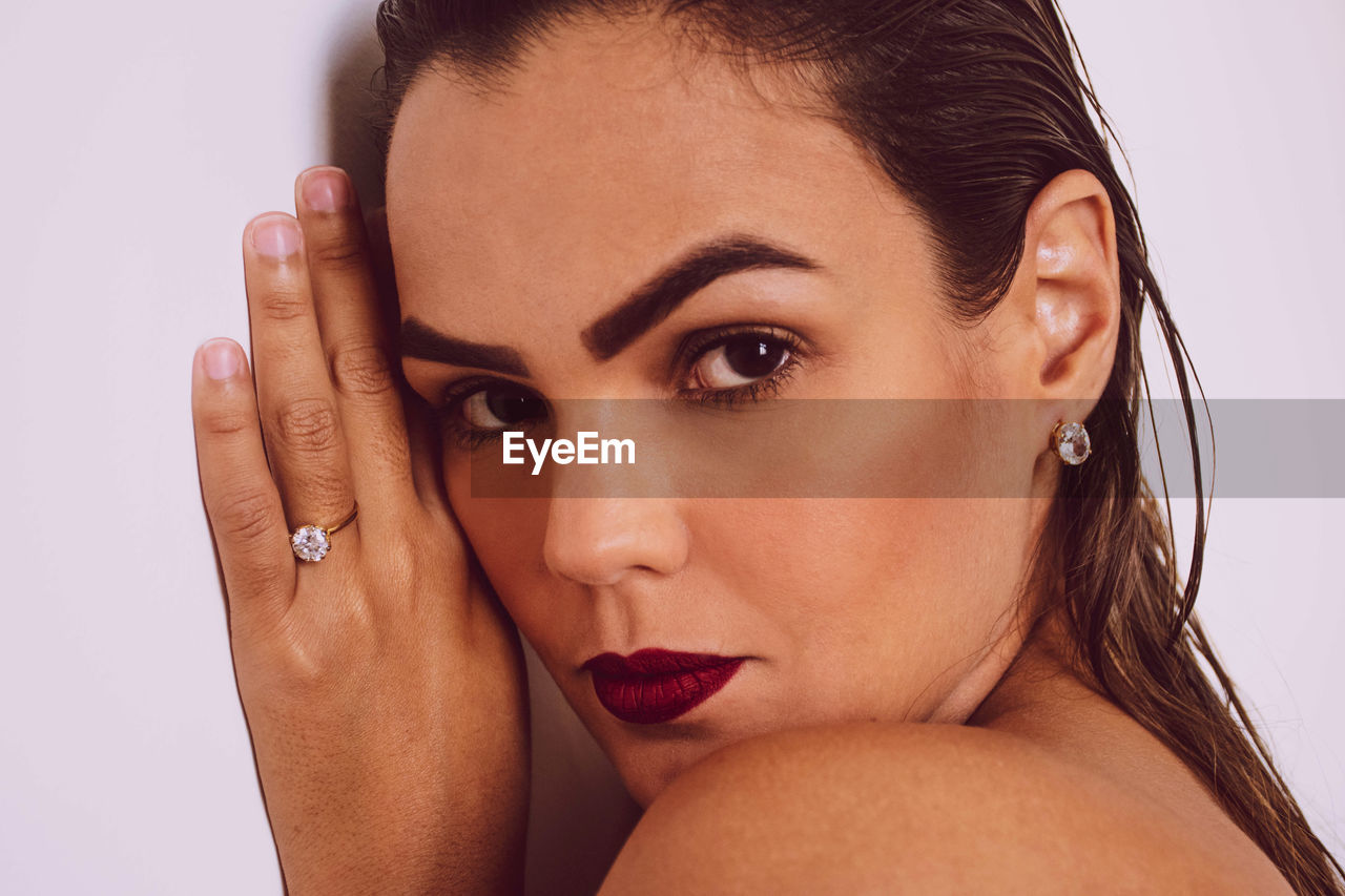 Close-up portrait of beautiful woman over white background