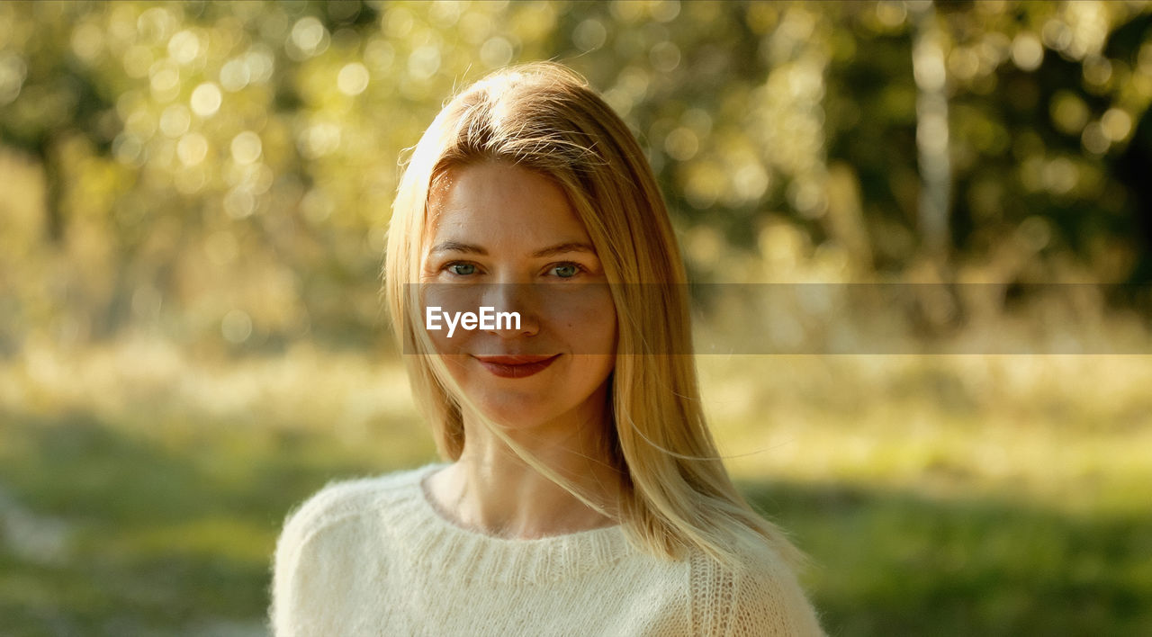 portrait of young woman standing against plants