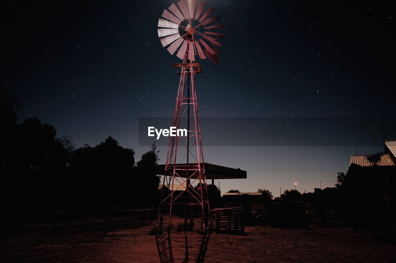 Low angle view of american style windmill on land against sky at night