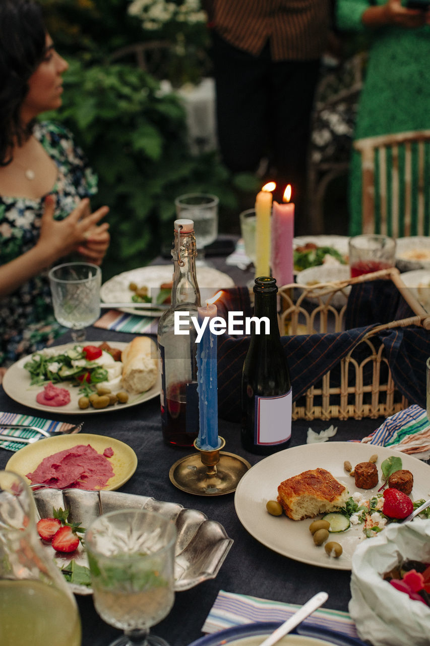 Food and drinks with illuminated candles at table during party