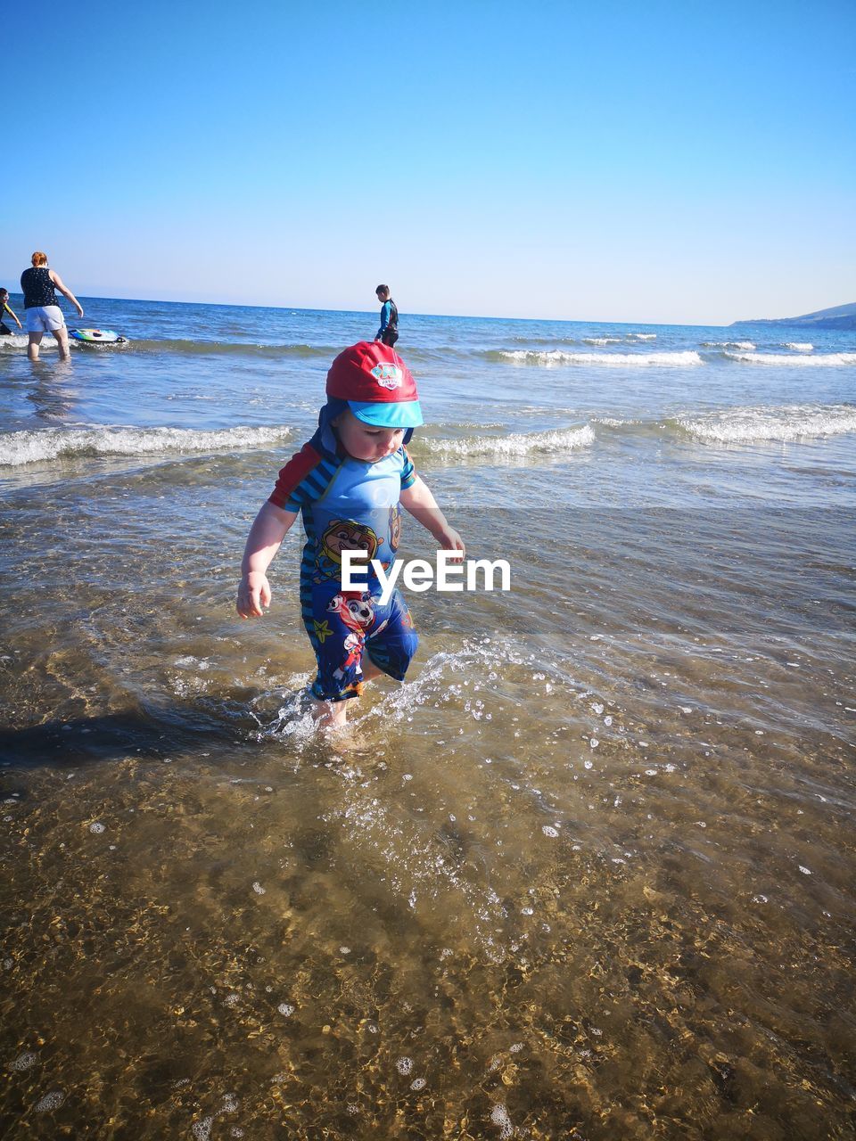 REAR VIEW OF MEN ON BEACH