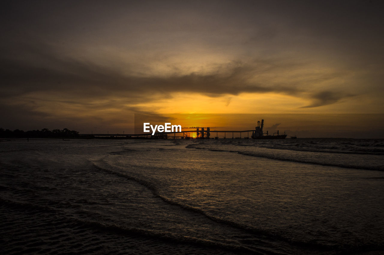 Scenic view of beach against dramatic sky