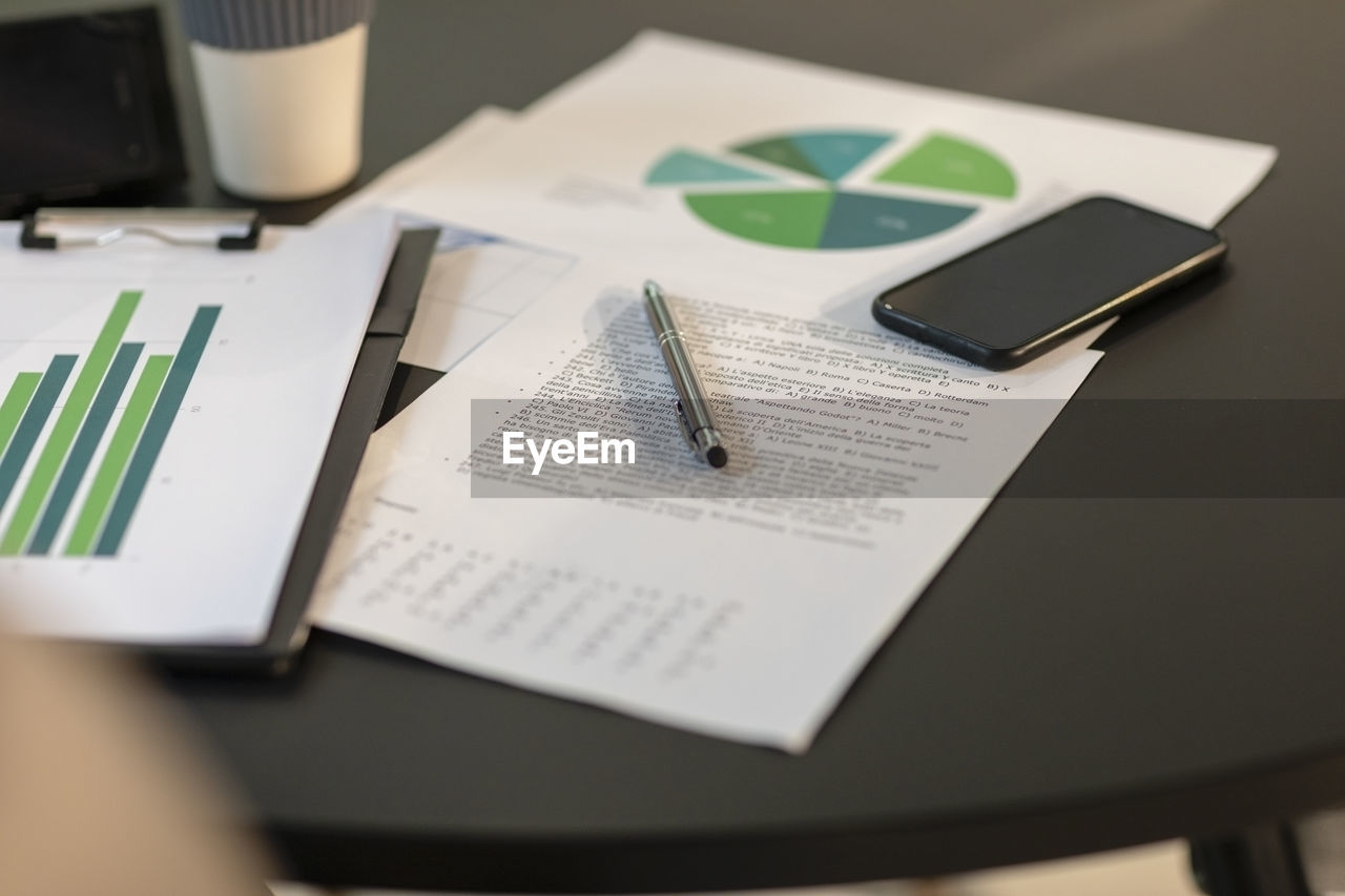 Paper documents and smart phone on table at office