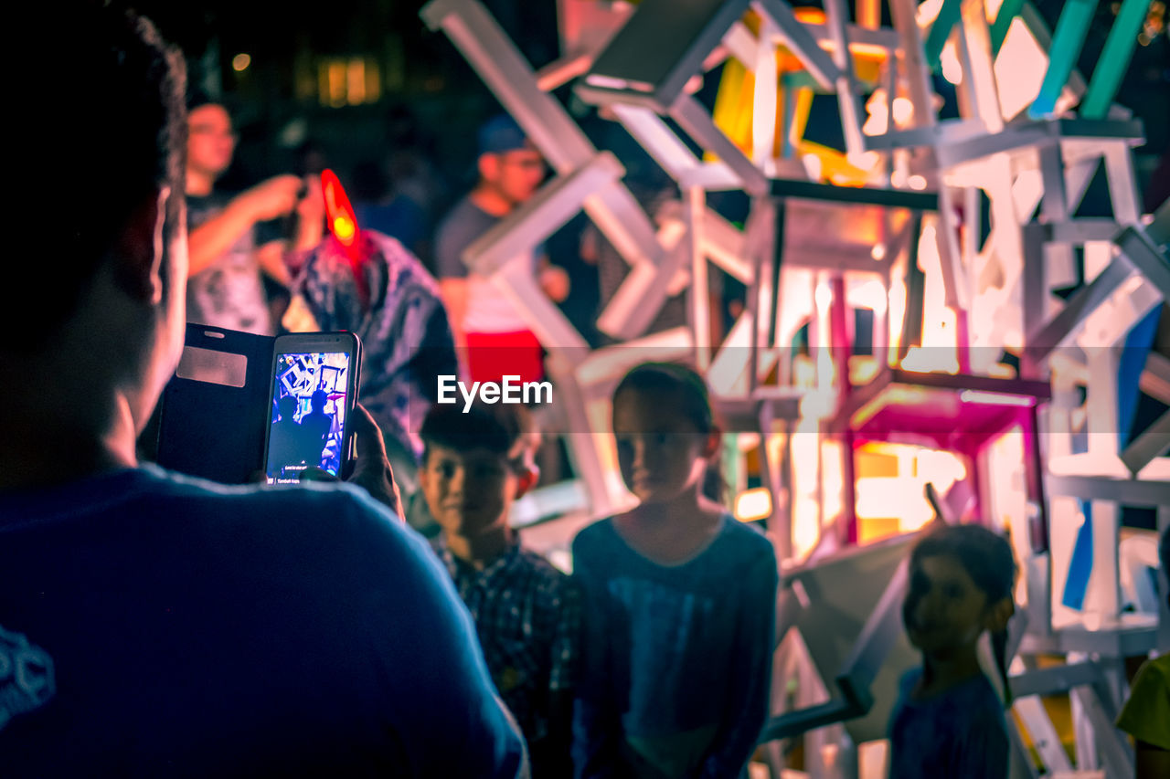 GROUP OF PEOPLE PHOTOGRAPHING IN MUSIC CONCERT