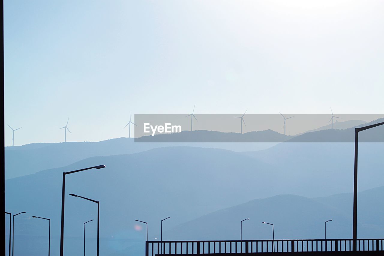 Wind turbines on mountain against sky