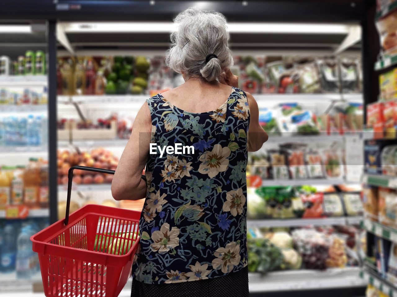 Rear view of senior woman shopping in supermarket