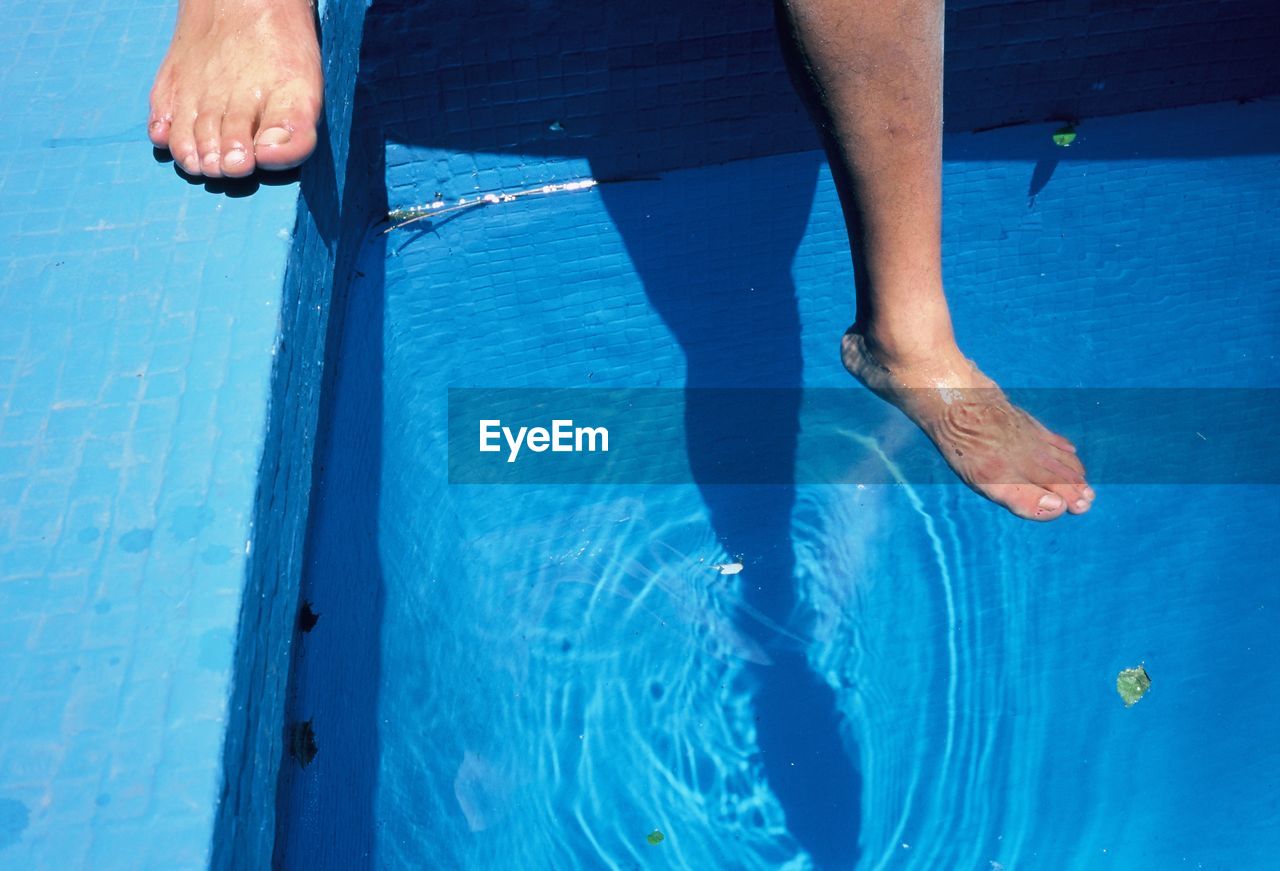 LOW SECTION OF MAN WEARING SWIMMING POOL