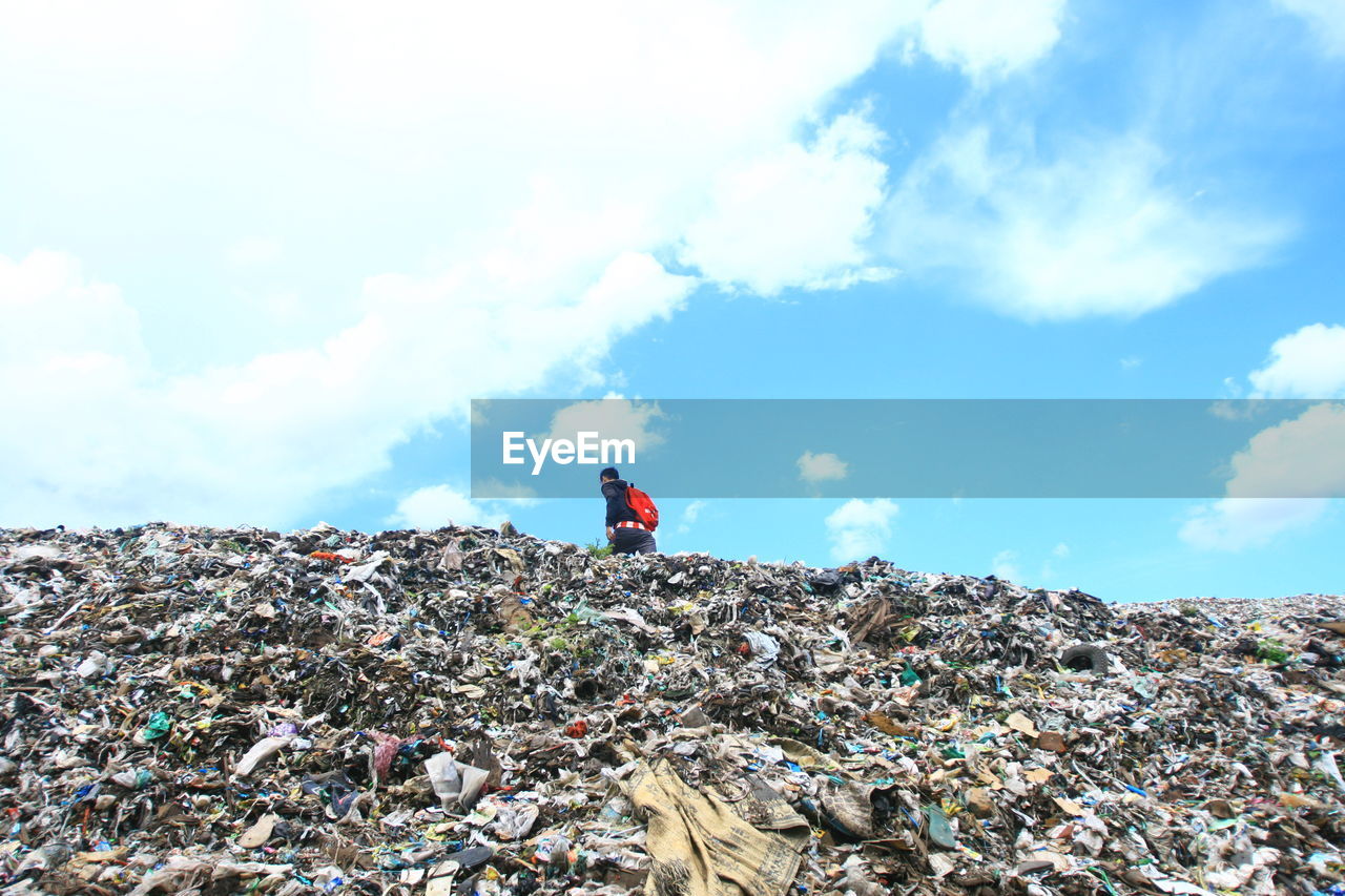 MAN WITH UMBRELLA ON GARBAGE