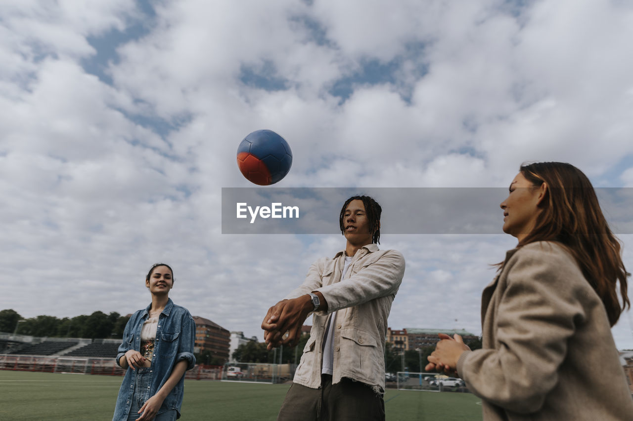 Smiling teenagers playing ball together