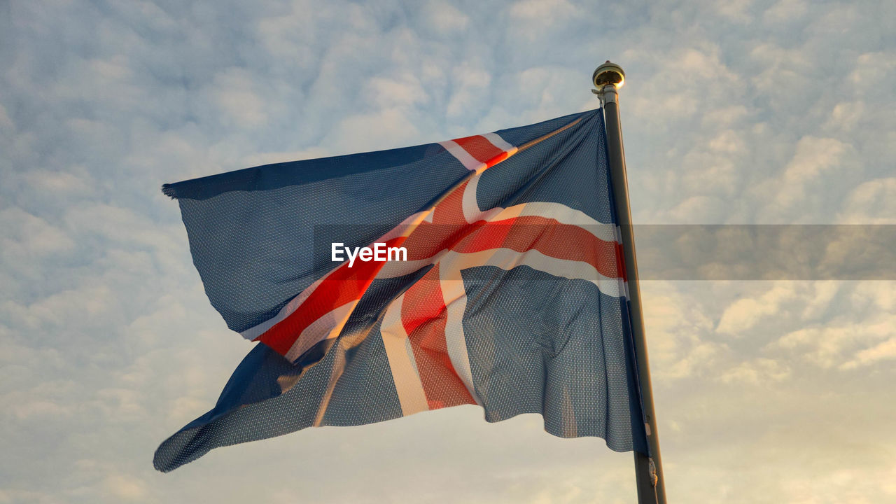 low angle view of flag against cloudy sky