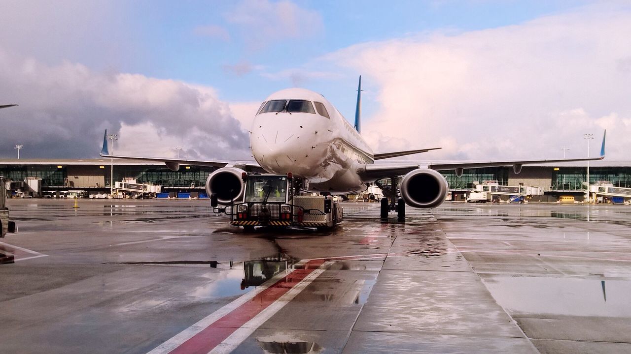 AIRPLANE ON RUNWAY AGAINST CLOUDY SKY