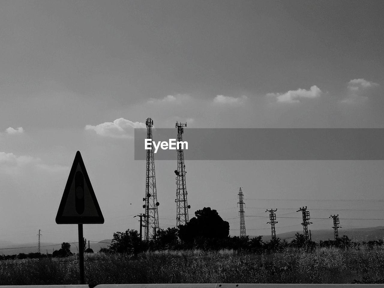 WINDMILLS ON FIELD AGAINST SKY