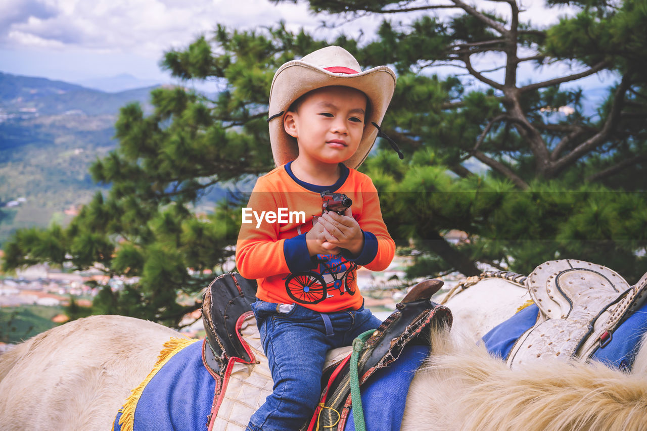 FULL LENGTH OF HAPPY BOY RIDING IN HAT