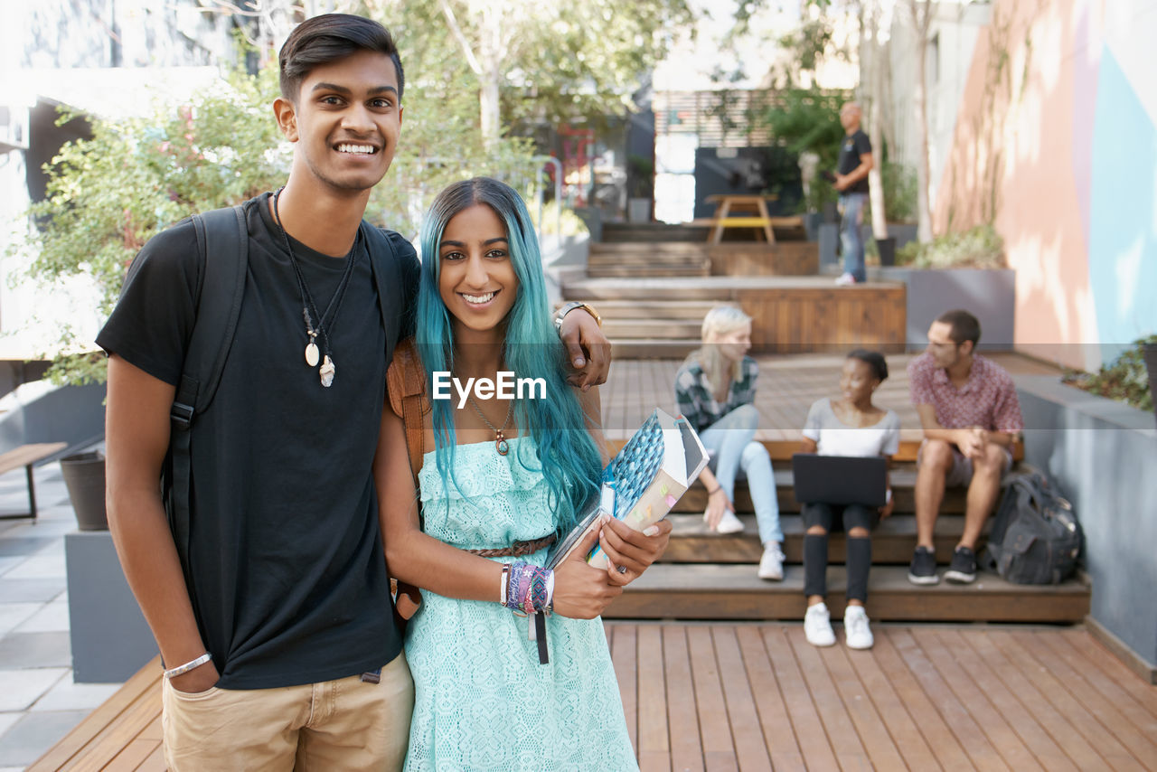 Portrait of couple with friends in background