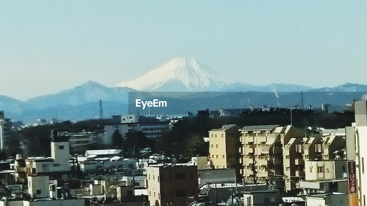 VIEW OF CITYSCAPE AGAINST MOUNTAIN