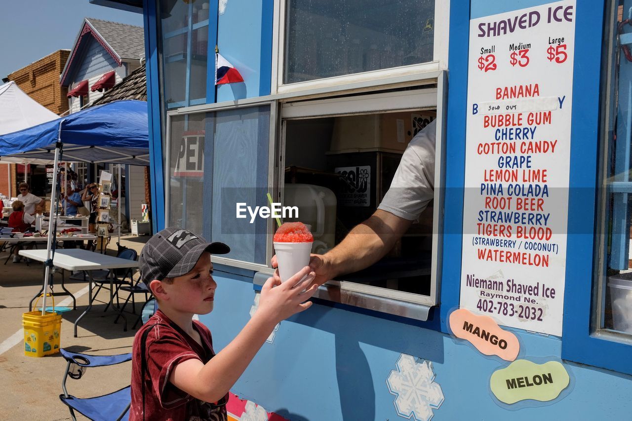 Boy buying sweet food from vendor