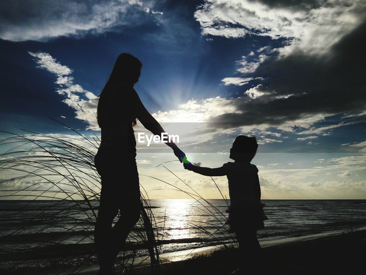 SILHOUETTE OF CHILDREN PLAYING ON BEACH