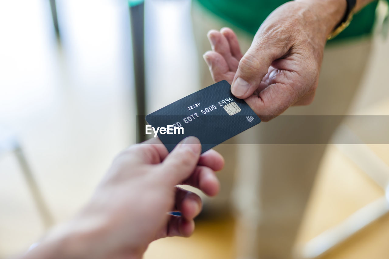 Close-up of two hands with credit card