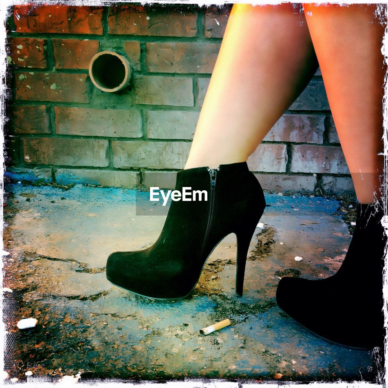 Low section of woman with high heels on street