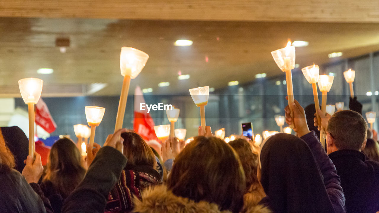 Crowd with illuminated candles in church