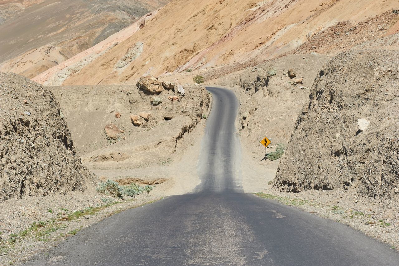 High angle view of empty road amidst landscape during sunny day