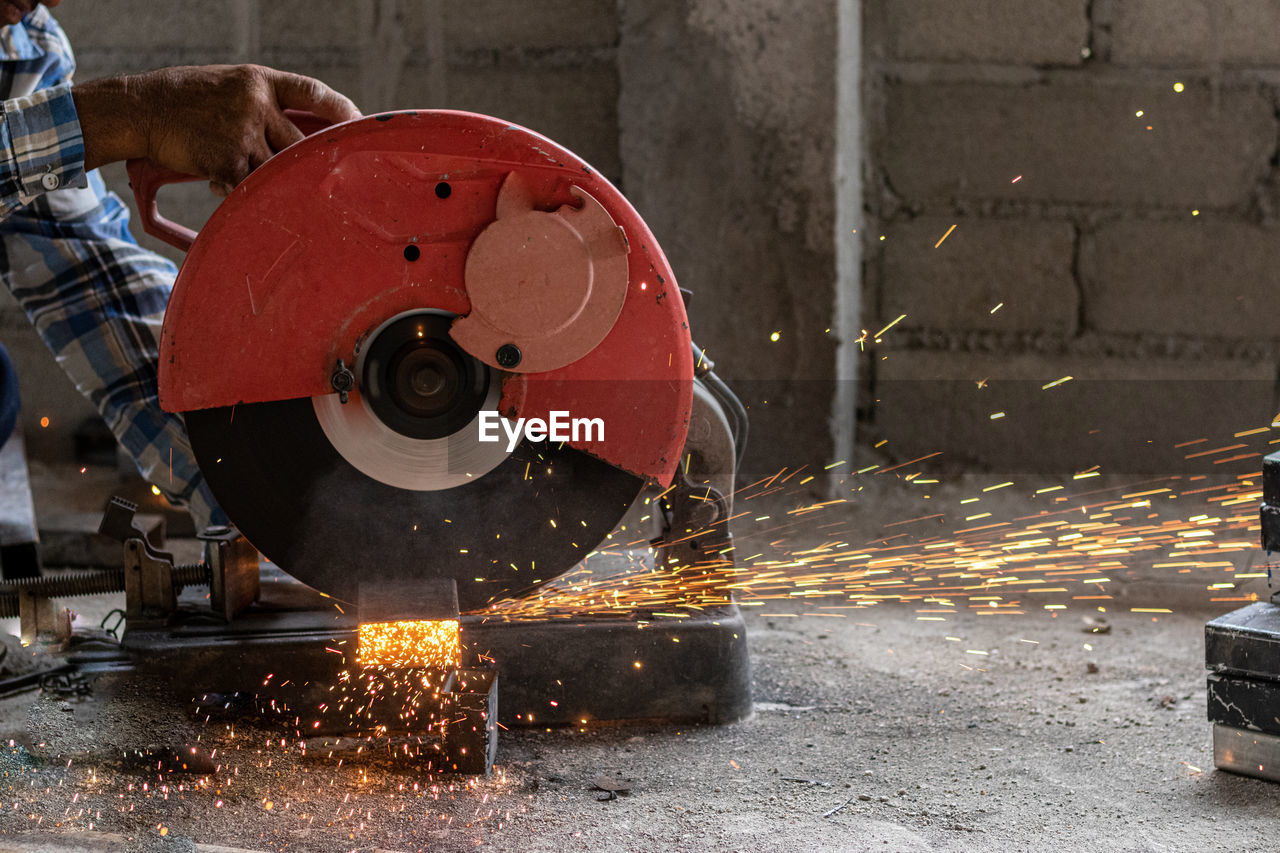 Low section of man cutting metal