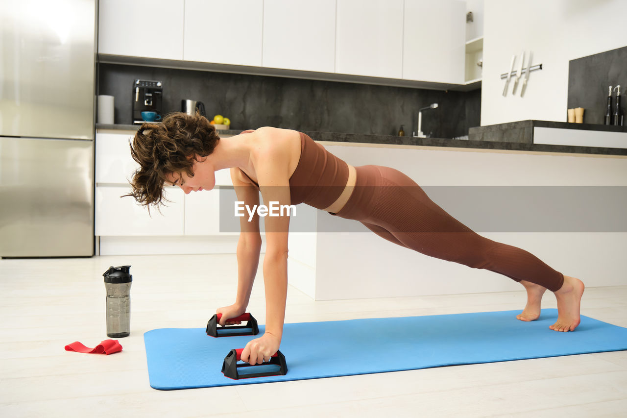 side view of woman exercising in gym