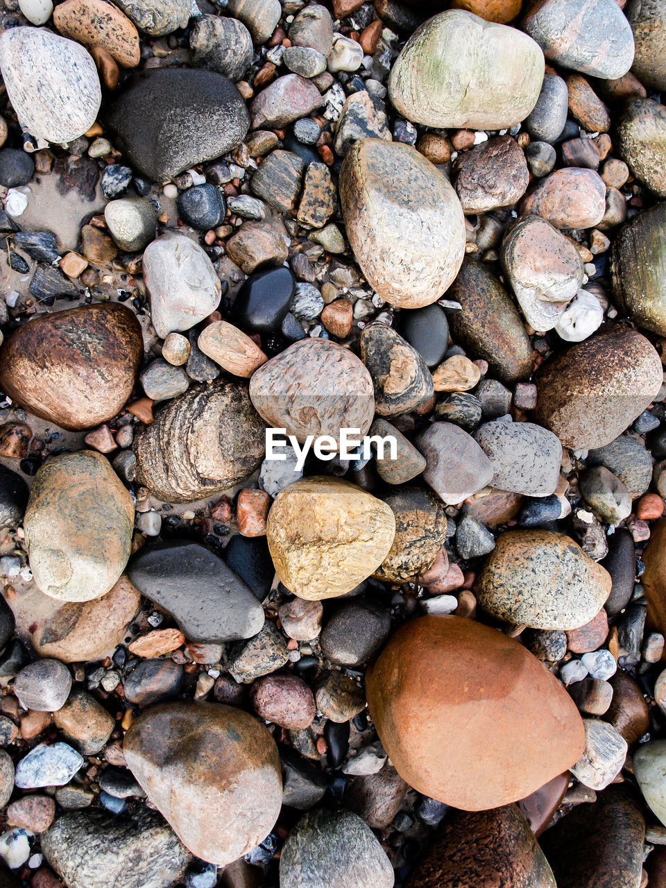 HIGH ANGLE VIEW OF STONES ON PEBBLES