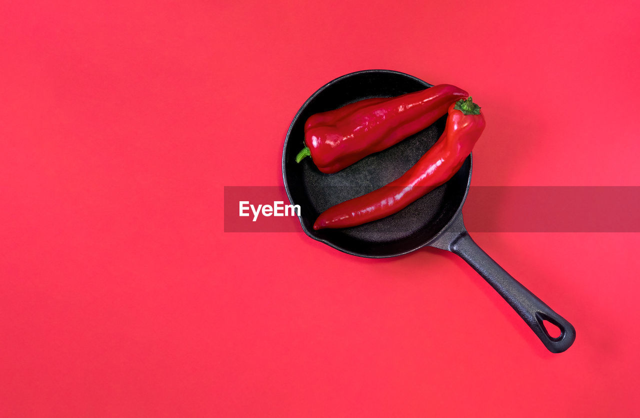 HIGH ANGLE VIEW OF RED CHILI PEPPER AGAINST ORANGE BACKGROUND