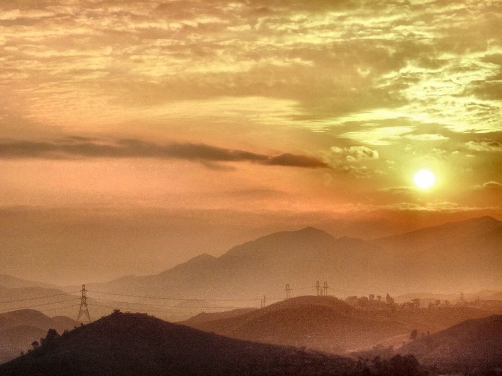 Scenic view of mountains against orange sky