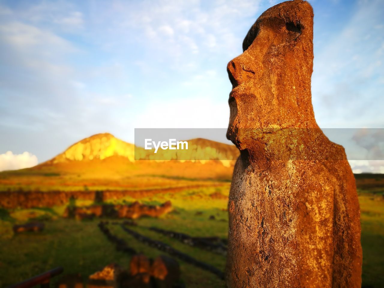 Moai statue at easter island against mountain during sunrise