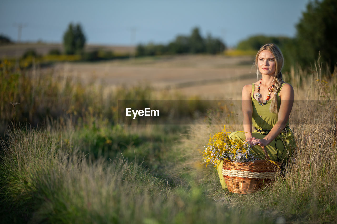 portrait of young woman sitting on grassy field