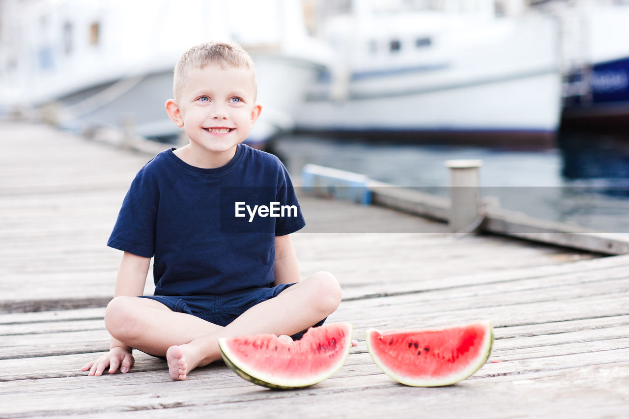 Smiling kid boy 4 year old eating fresh watermelon outdoors. happy child.