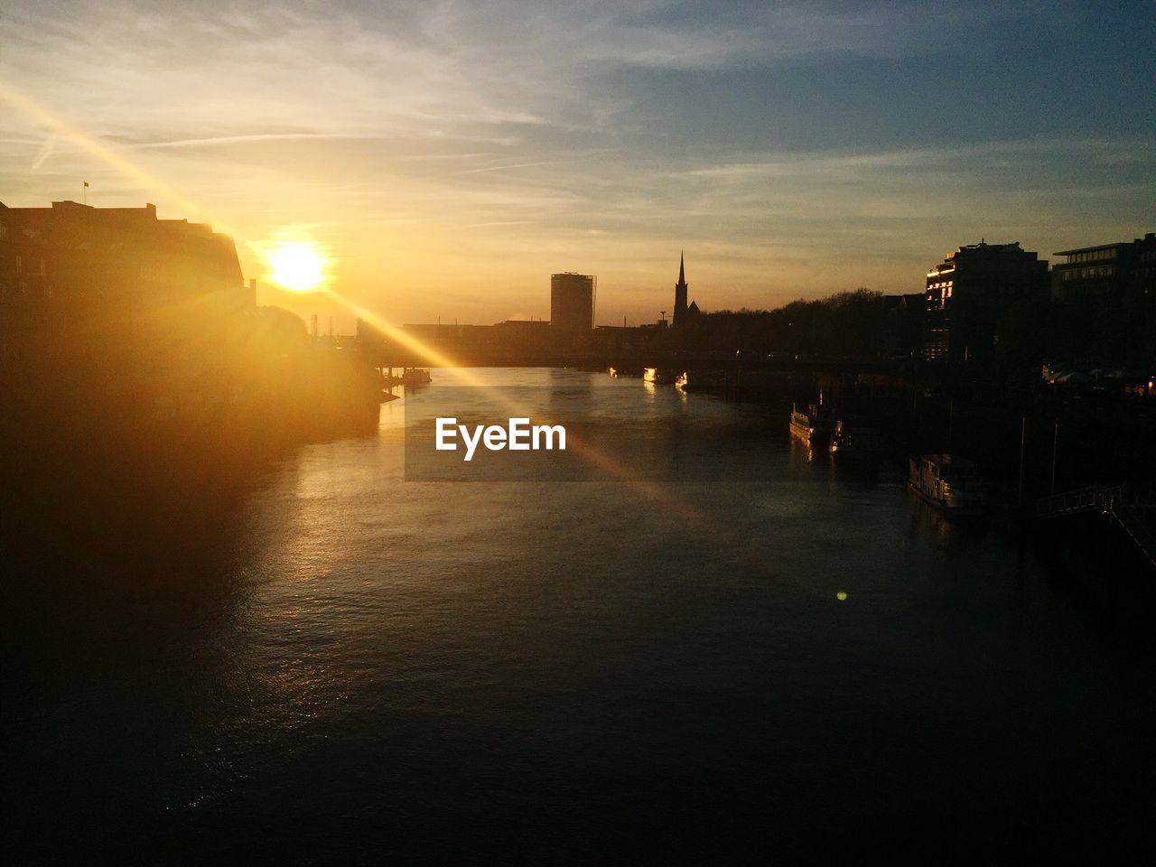 Canal against sky during sunset in city